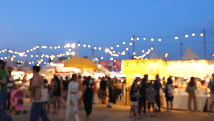 Blurred busy busy fresh market full with crowd people walking in street shopping.
Thailand street food night market booth festival light bright bokeh. Slow motion of video 4K.