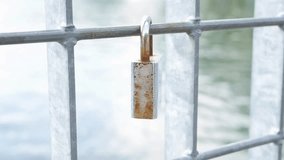 Old rusty padlock hanging on metal fence closeup.
Video footage of an old, weathered padlock with visible rust and corrosion hanging from a metal fence or railing. - Powered by Shutterstock - Get 15% off with code: PIKWIZARD15