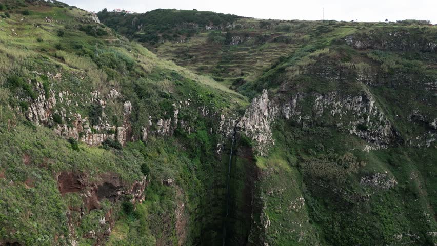aerial view of a waterfall and green cliffs