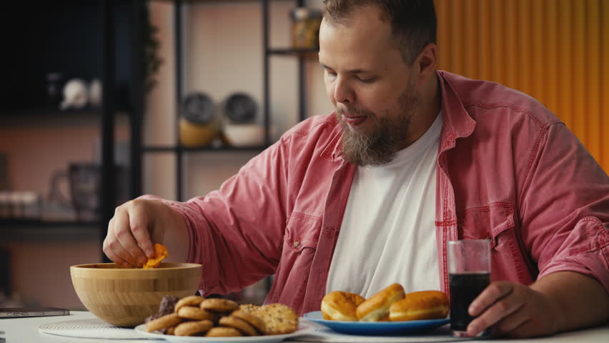 Plus-size man eating food high in added sugar, struggling with overeating habits