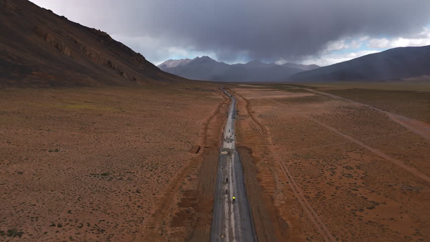 Bikers Riding Across Arid Tibetan Valley