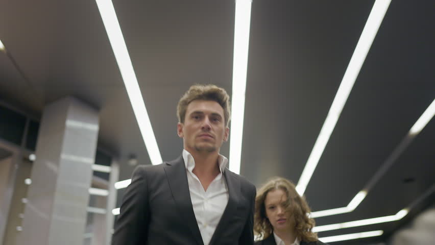 A dynamic and lively scene of business professionals walking confidently through a modern office space