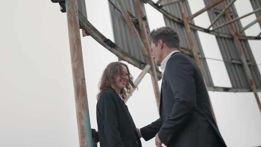 A stylish and fashionable couple shares a tender and intimate moment against an inspiring urban backdrop