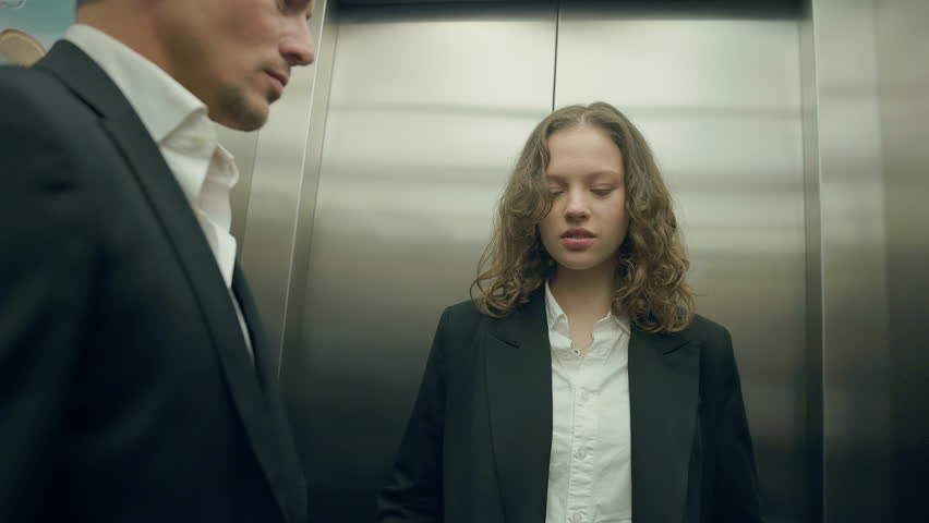 A tense, gripping moment unfolds dramatically between two professionals in a powerful elevator scene