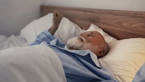 Senior man smiling and stretching hands after waking up, morning routine - Powered by Shutterstock - Get 15% off with code: PIKWIZARD15