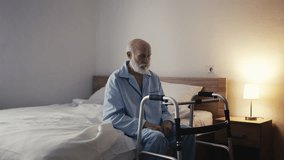 Elderly man using walker inside home, struggling with illness in old age - Powered by Shutterstock - Get 15% off with code: PIKWIZARD15