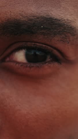 Vertical video, Close Up of a Young Man's Eyes as He Opens Them and Looks at the Camera. Perfect for Projects Related to Vision, Focus, or Awakening.