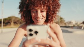 Smiling sports woman using phone at outdoor gym. Happy female athlete checking messages or social media after training. Fitness, health, and technology. - Powered by Shutterstock - Get 15% off with code: PIKWIZARD15