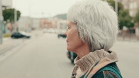 A thoughtful senior woman waits patiently at a busy intersection. She reflects in quiet contemplation. Perfect for themes of retirement, city life, and everyday moments. - Powered by Shutterstock - Get 15% off with code: PIKWIZARD15