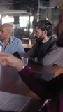 Vertical. Diverse team of professionals engages in a productive meeting, utilizing laptops for data analysis and collaborative discussion in a vibrant, modern office environment - Powered by Shutterstock - Get 15% off with code: PIKWIZARD15
