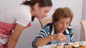 Loving grandmother guiding young granddaughter while decorating colorful cupcakes, sharing delightful baking moments in cozy kitchen setting - Powered by Shutterstock - Get 15% off with code: PIKWIZARD15