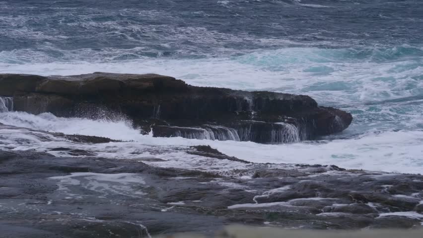 Drone captures the rugged rocky coastline of Fort Bragg, California, with waves forcefully crashing against the shore, showcasing natural coastal power.