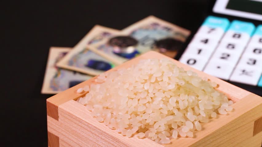 Rice in a wooden box, Japanese money and a calculator：rotating