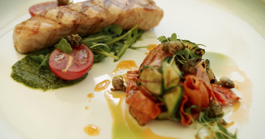 Grilled fish, grilled salmon steak, aromatic spices and vegetables on white plate. Grilled salmon fish with various vegetables. Concept of healthy food and of freshly salmon. Close up.