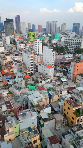 Aerial view of Ho Chi Minh City skyline with dense low-rise buildings contrasting with modern skyscrapers, Vietnam. Urban growth, contrast, and architecture themes.