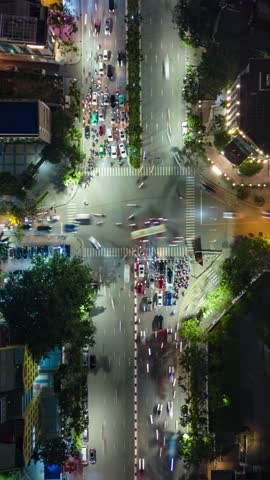 Aerial timelapse of evening traffic at busy intersection in Hanoi, Vietnam. Iluminated streets and vibrant urban movement ideal for city, travel, and Asia themes.
