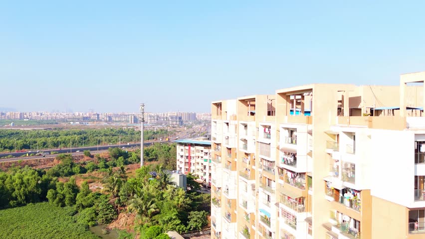 Drone Capture of Residential Zone Beside Verdant Landscape, Aerial View Cityscape with Highways and Green Fields, Urban Expansion Framed by Nature near Expressways, Housing Blocks along Traffic Routes