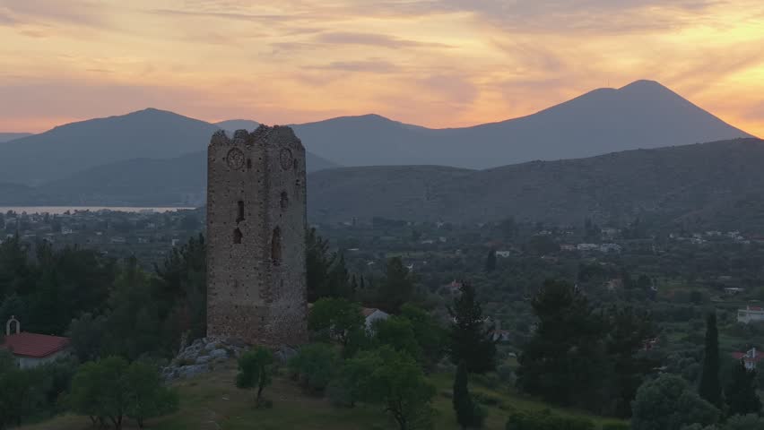 Ancient Stone Tower in the Historic Lilandio Area, Greece, Under an Orange Twilight Sky