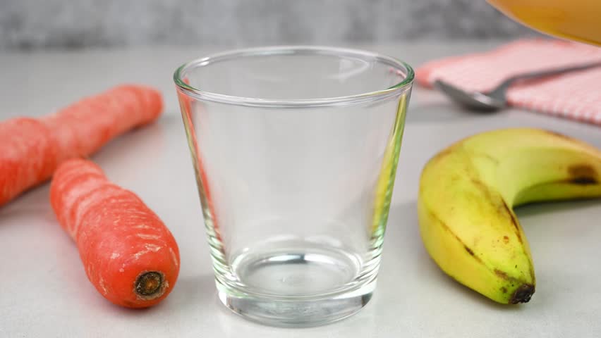 Serving carrot banana smoothie in a glass cup.