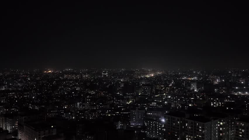 Drone view of Dhaka, the capital of Bangladesh at night, showcasing the glowing cityscape and illuminated urban architecture