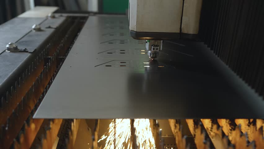 Industrial laser cutting metal sheet, creating precise shapes