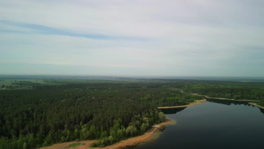flying over a forest lake. The water surface reflects trees, calm water and complete calm on the lake.