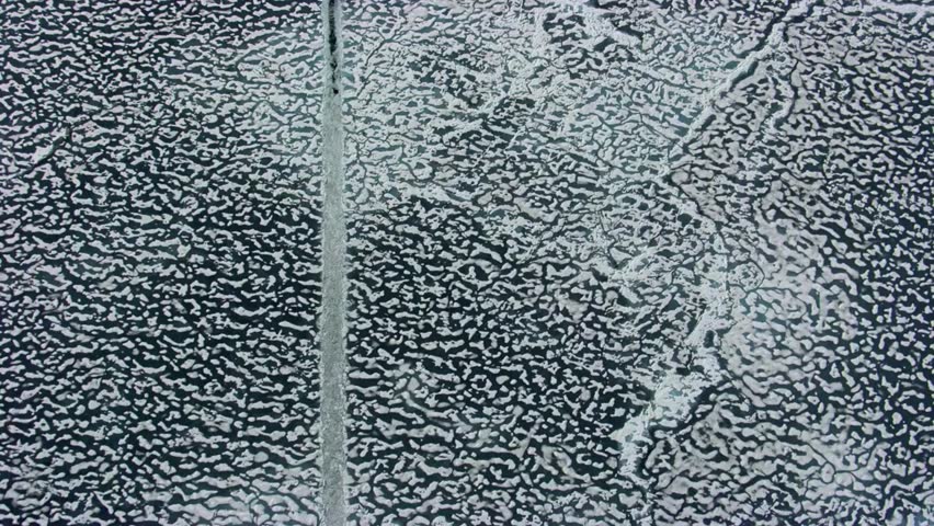 Aerial View of Frozen River with Ice Patterns and a Straight Line