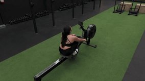 Determined mexican sportswoman practicing rowing exercise on a fitness machine in a modern gym - Powered by Shutterstock - Get 15% off with code: PIKWIZARD15