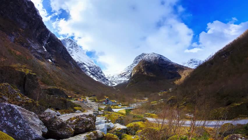 Majestic Mountain Valley Landscape with Stream and Snow-capped Peaks
