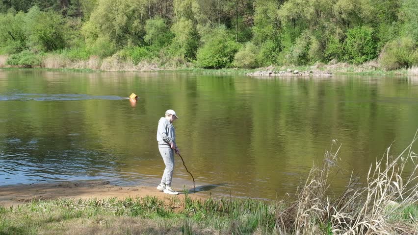 a boy walks in the forest near a lake or river