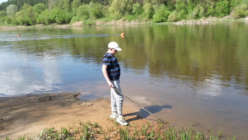 a boy walks in the forest near a lake or river