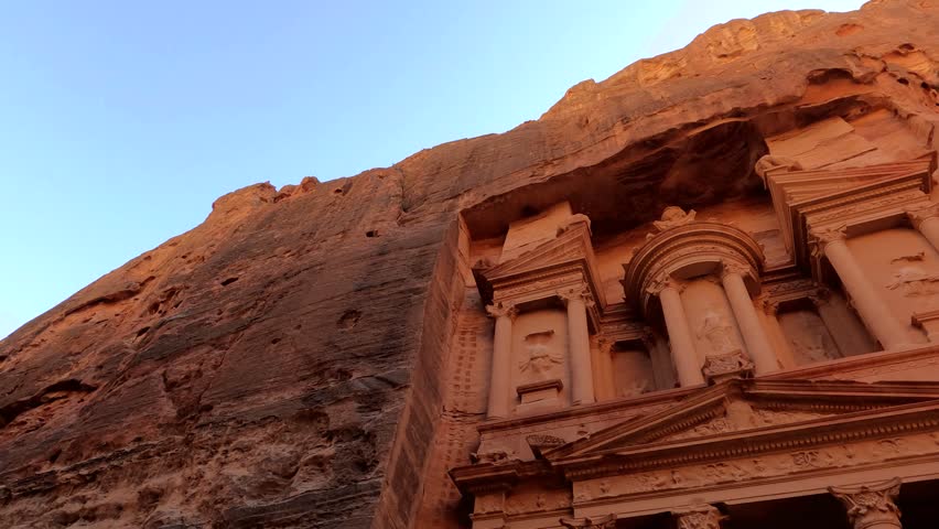Low angle view of the ancient rock-carved Treasury facade, an iconic landmark in Petra, Jordan.