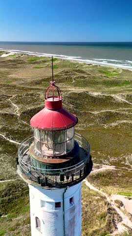 Explore the stunning coastal landscape of Lyngvig Lighthouse Hvide Sande in Jutland, Denmark. The majestic lighthouse overlooks the dunes and glistening waves