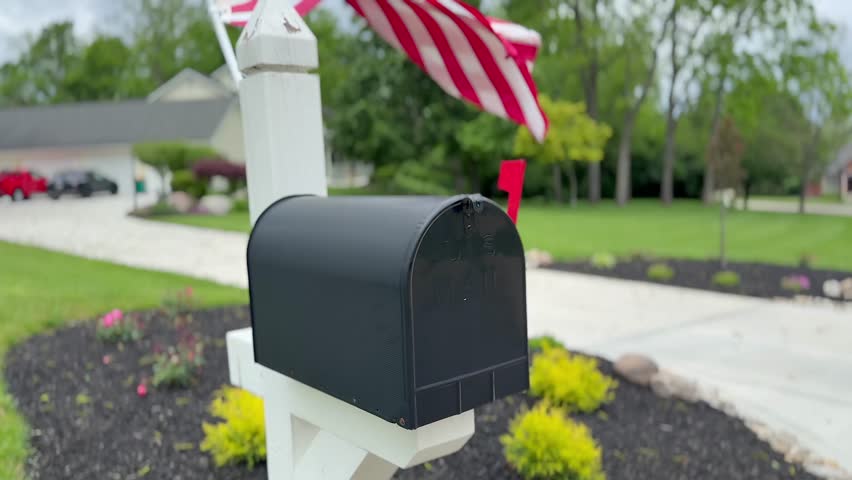 Flag flapping behind a black mailbox. Slowed to half speed