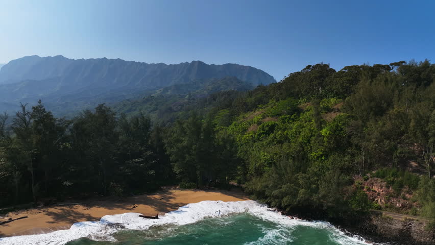 Aerial tracking shot of mountainous nature of Kauai, sunny day in Hawaii, USA
