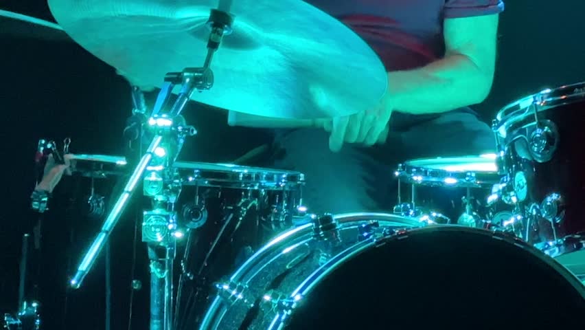 Closeup playing drums drum kit cymbal rock n' roll band music blue neon glow