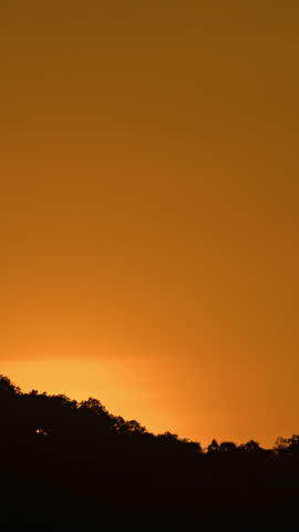 Breathtaking beauty of the sun rising time lapse video over a rugged mountain ridge on a cloudy morning.
