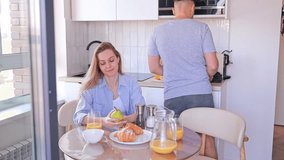 A couple enjoying a warm moment of breakfast with croissants, coffee and orange juice, sharing a laugh in their kitchen. Concept: lifestyle brands, family events, culinary experiences. - Powered by Shutterstock - Get 15% off with code: PIKWIZARD15