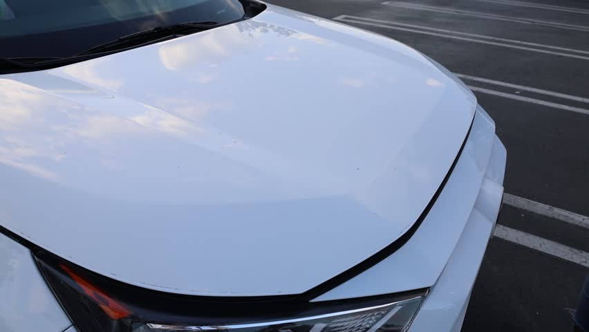 Women open white car hood