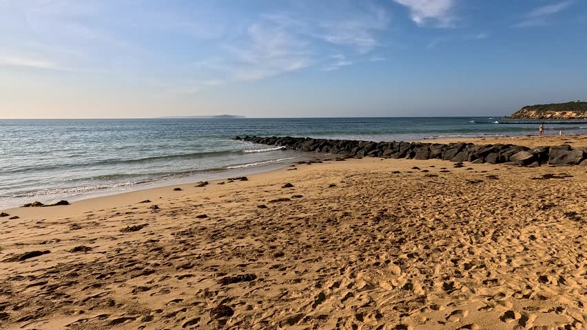 A serene coastal path along Point Lonsdale beach under clear blue skies, showcasing the natural beauty and tranquility of the area