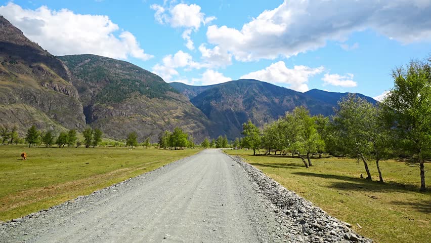 Dirt road running along Chulyshman river at entrance to Chulyshman valley in Altai Russia Scenic remote route through wild mountain landscape. High quality 4k footage