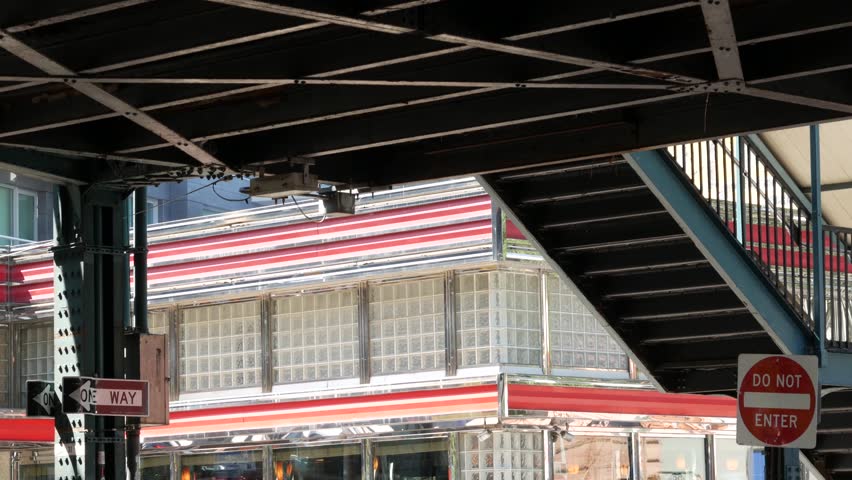 New York elevated subway, metropolitan bridge, metro track above street. Railway transport over road. Railroad line. Old cafe, diner restaurant. Court Square, Long Island city, Queens, United States