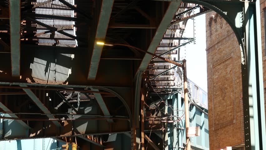 New York elevated subway, metropolitan bridge, metro track above street. Railway transport over road. Train on railroad line. Queens public transportation. Brown brick. Long Island city, United States