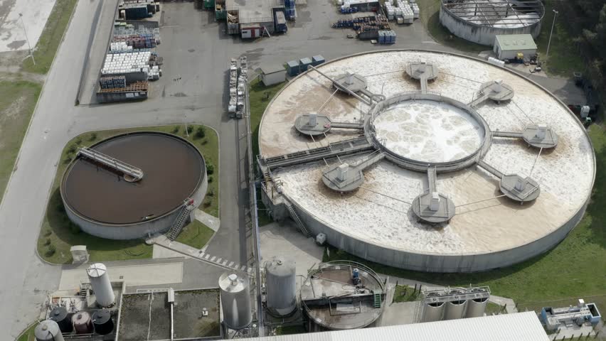 Aerial circling large circular water treatment or settling tanks at DRT industrial factory complex, Veille-Saint-Girons, France