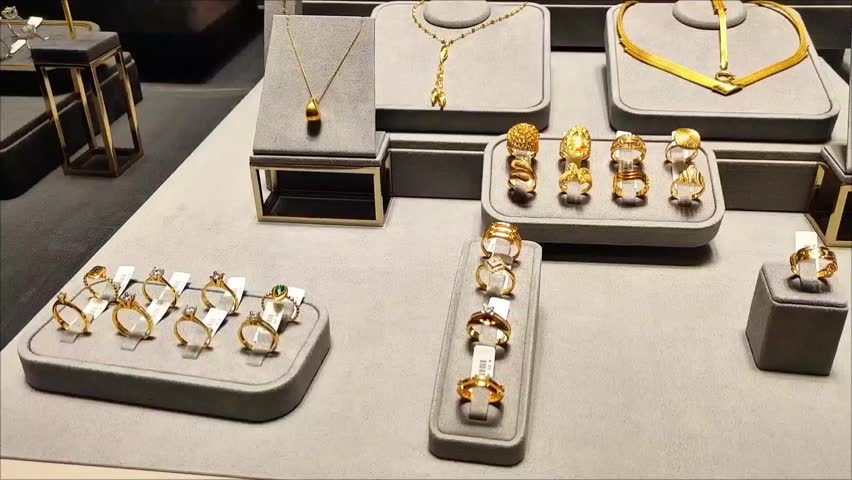 Women's gold jewelry, rings, earrings, bracelets and necklaces with precious stones in the shop window