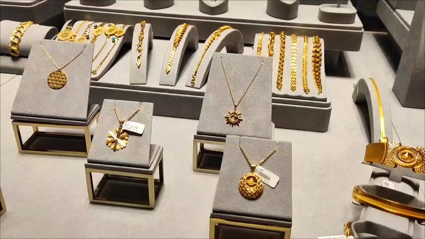 Women's gold jewelry, rings, earrings, bracelets and necklaces with precious stones in the shop window