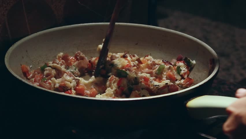 Adding rice to a pan of sauteed vegetable cubes and scrambled eggs for a simple yet healthy vegetarian fried rice recipe, home cooking in candid daily life