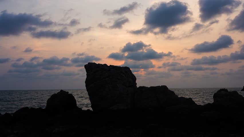 sunset on the sea with silhouette mountains	