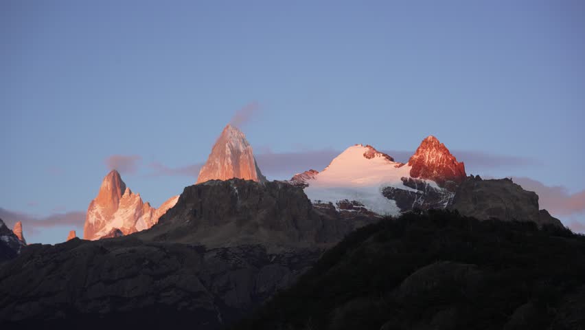 Cerro Electrico and Mount Fitz Roy lit by warm sunset light, El Chaltén, Patagonia, Argentina. Cloud movement and changing light timelapse