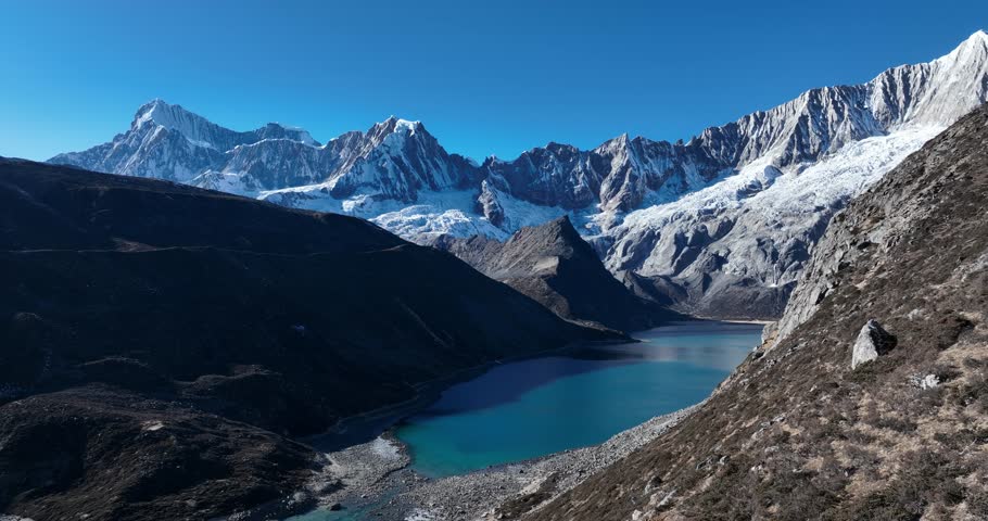 Aerial footage of beautiful snow capped mountain and lake sunrise landscape in Tibet, China
